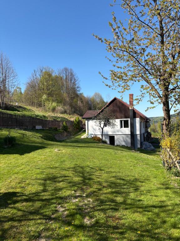 a house in the middle of a grassy yard at Dom w górach Zacisze lasu z prywatną balią in Sucha Beskidzka