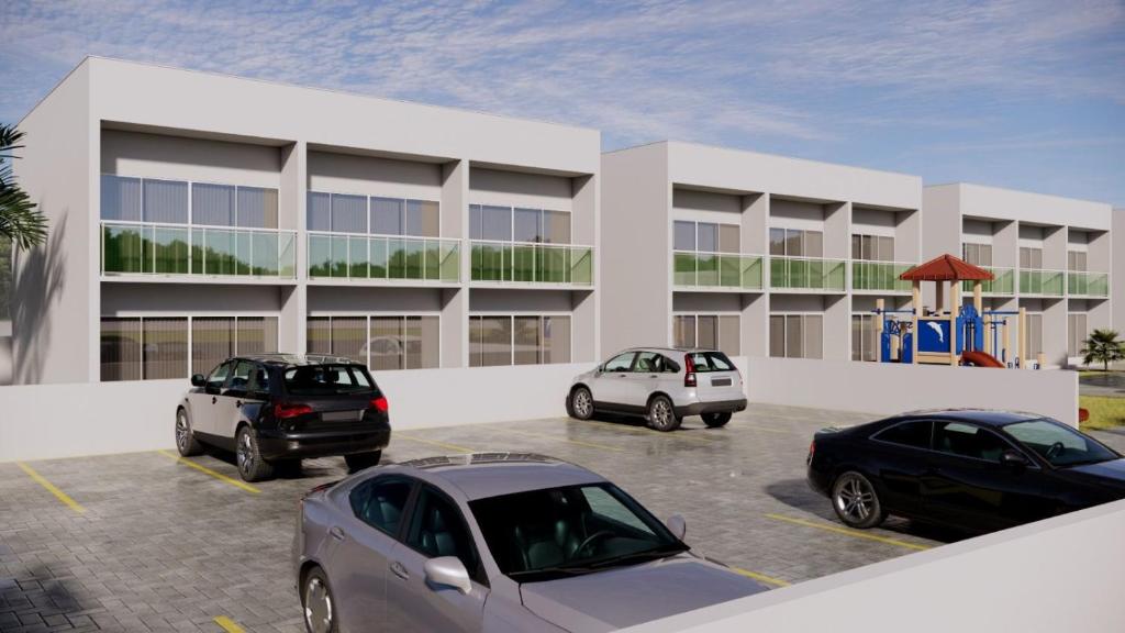 three cars parked in a parking lot in front of a building at Costa Atlântico House in Garopaba