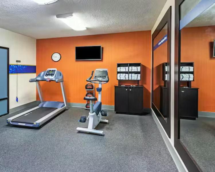 a room with a gym with a treadmill and a tv at Aiken Midtown Hotel in Aiken