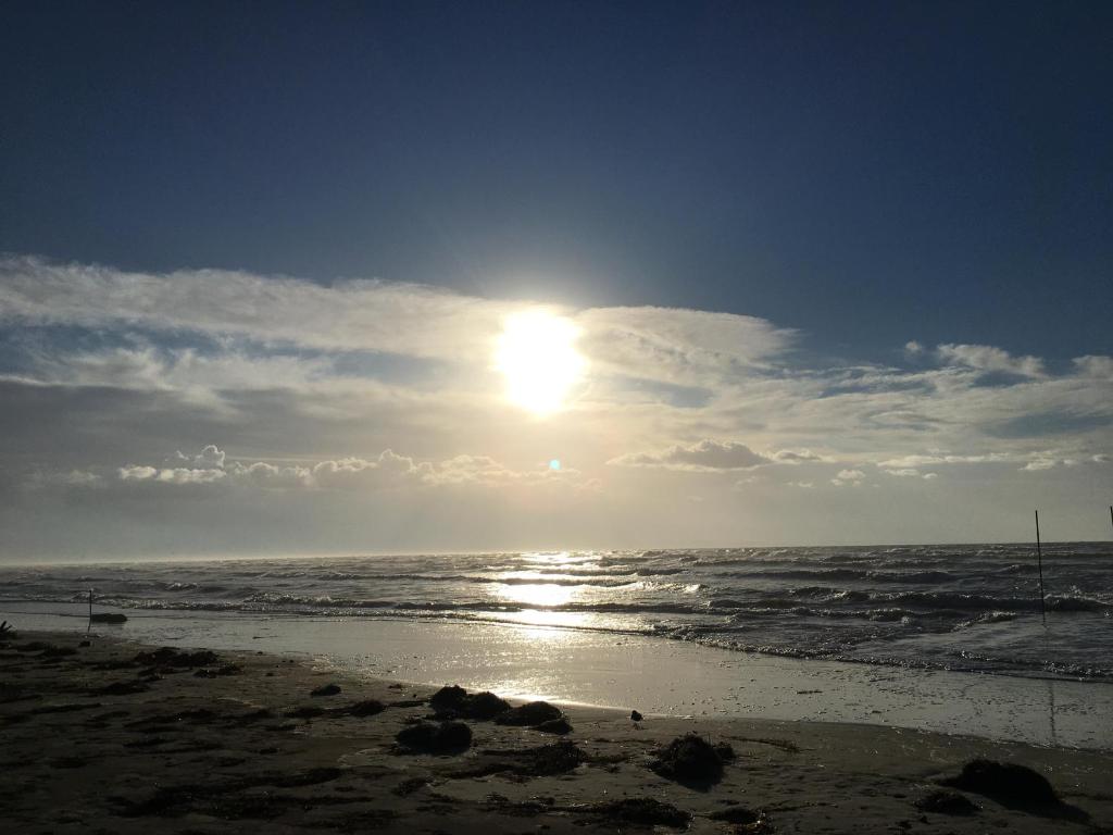 a sun setting over the ocean on a beach at Studio Artemisia in Grado