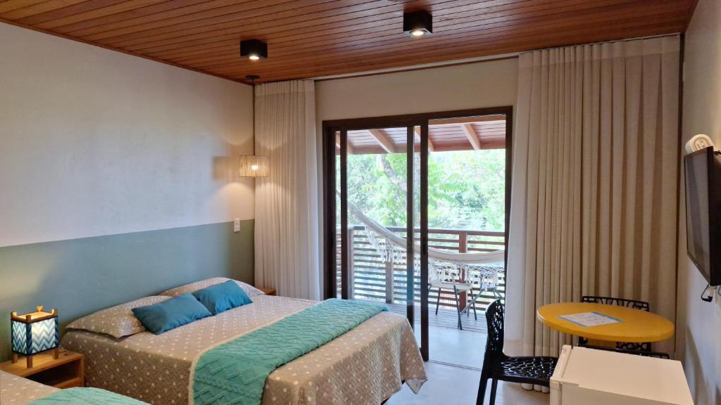 a bedroom with a bed and a balcony at Vila no Rosa Hospedaria in Praia do Rosa