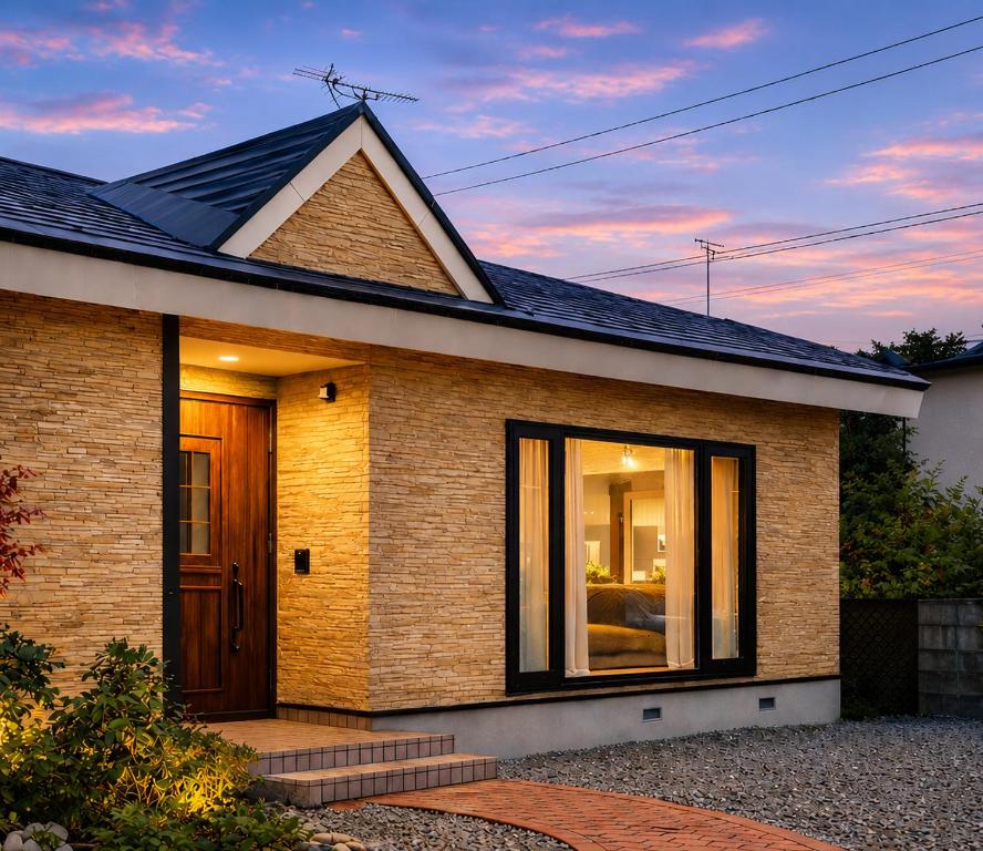 a brick house with a front door at dusk at House Villa Koharu in Asahikawa