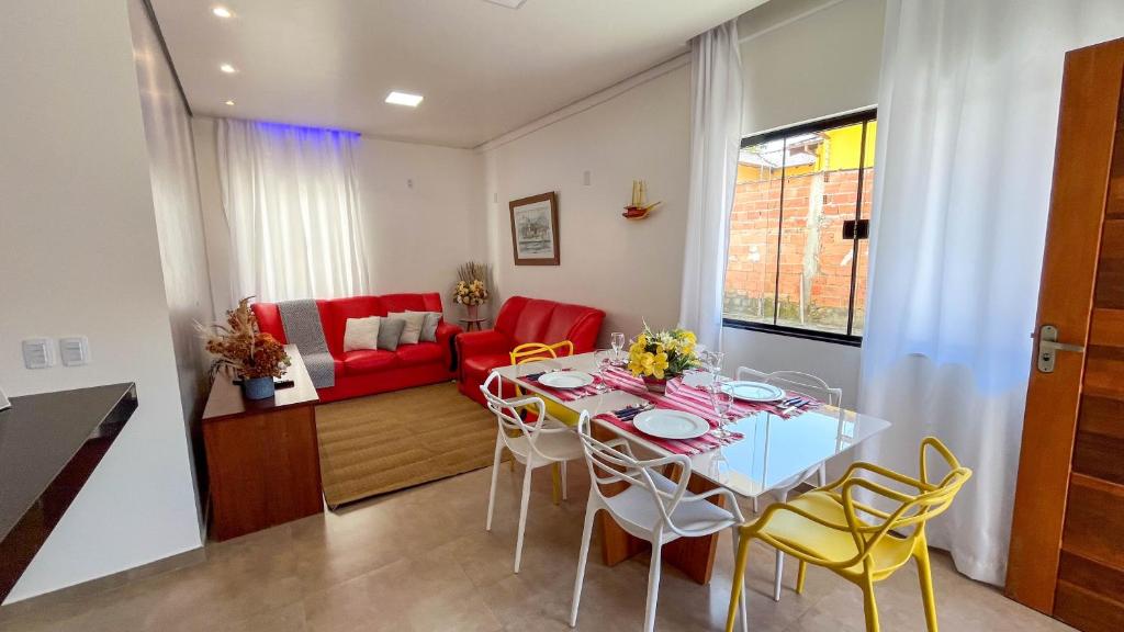 a living room with a table and a red couch at Casa Amoreira Paraty in Paraty