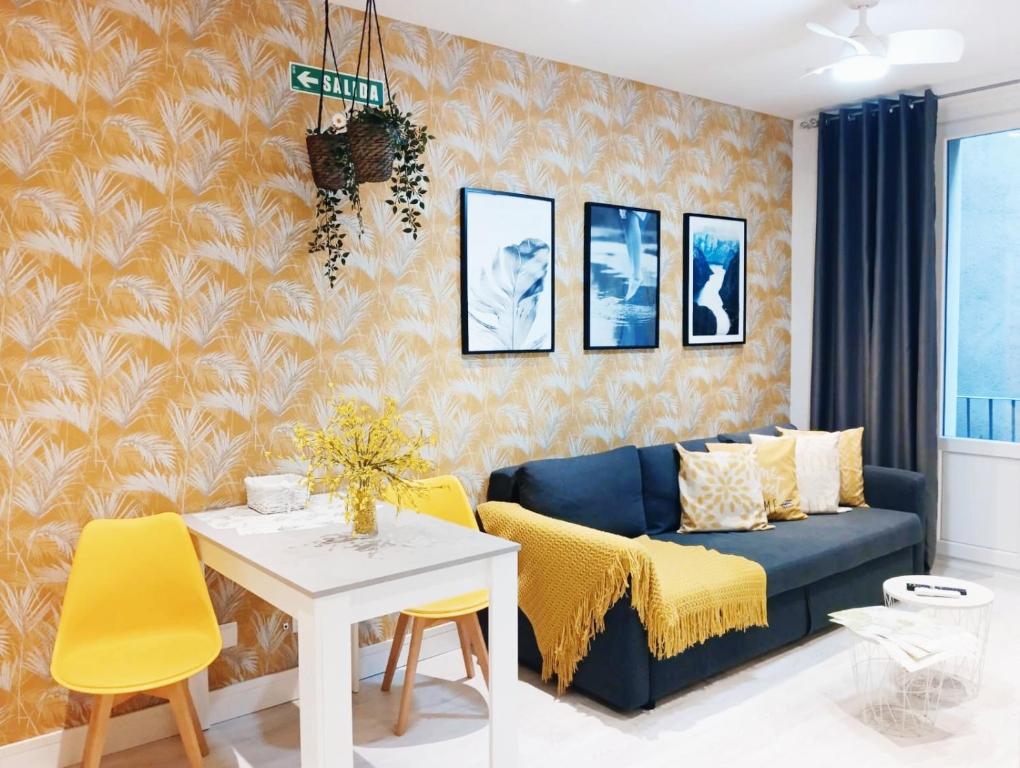 a living room with a blue couch and yellow chairs at JARAUTARESORT in Pamplona