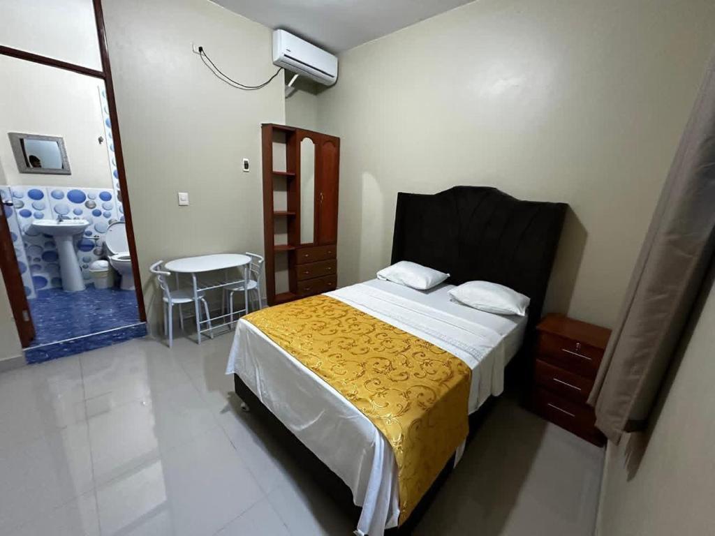 a bedroom with a bed with a yellow blanket at California Bambú in Iquitos