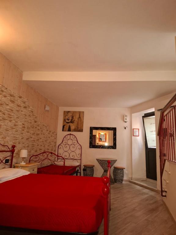 a bedroom with a red bed and a brick wall at Suite delle Nereidi in Manarola