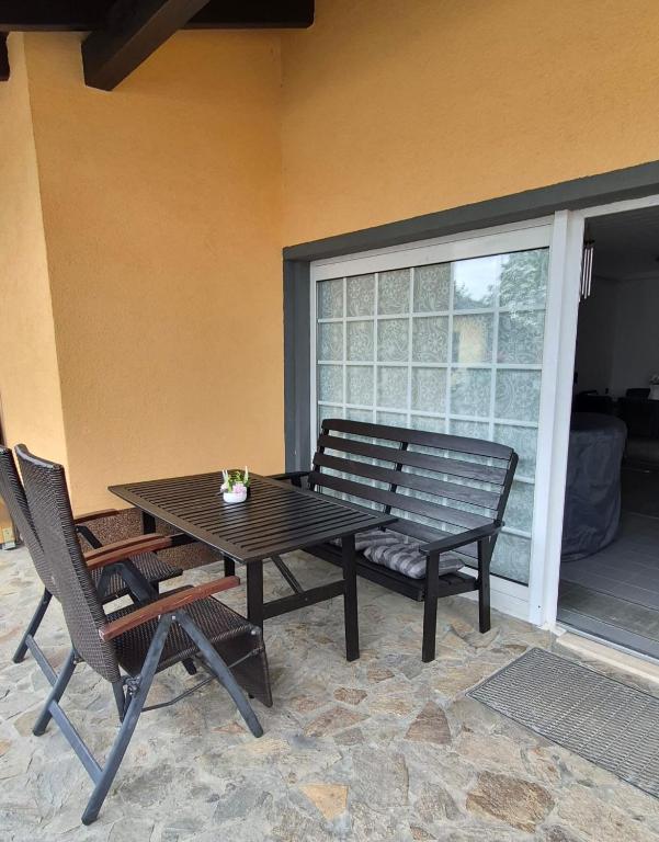 a table and chairs and a bench on a patio at Ferienwohnung Alex in Nidderau