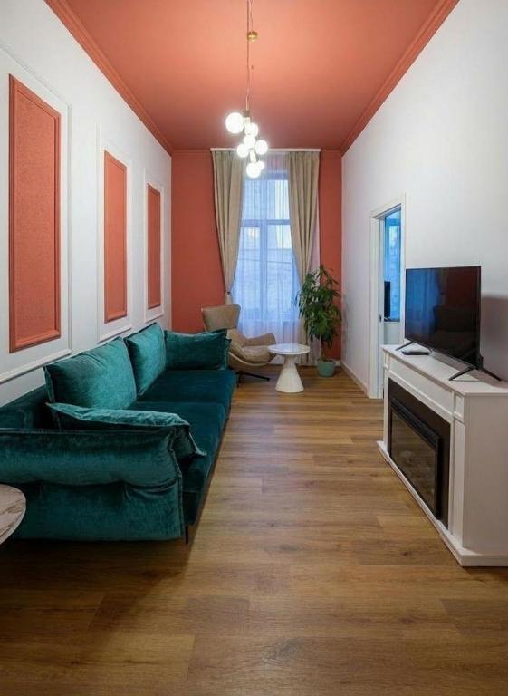 a living room with a green couch and a television at Central Residence Aiud in Aiud