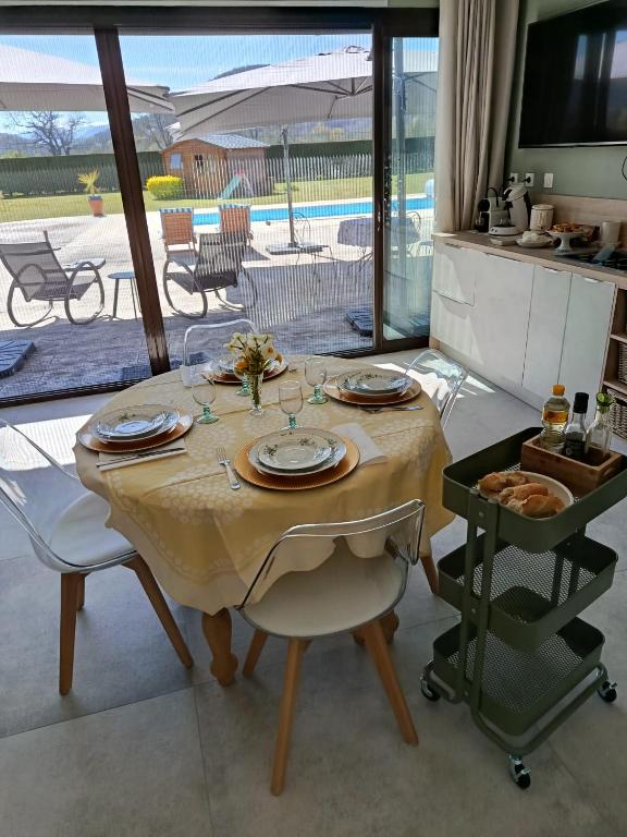 a table with plates and glasses on it in a kitchen at La PETITE MAISON in Gourdan-Polignan