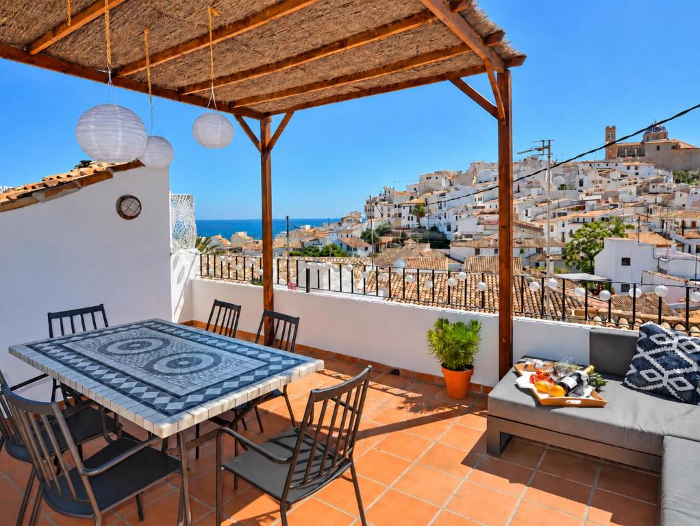 a balcony with a table and chairs and a view of positano at Casa en Bellaguarda by NRAS in Altea