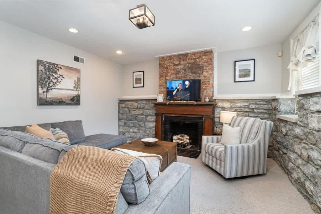a living room with a couch and a fireplace at Rutledge After Dark - Walk to Broadway & The Gulch in Nashville