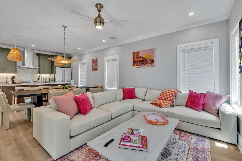 a living room with a white couch and pink pillows at Resonant - 2 Townhomes - 2 Private Rooftop Decks in Nashville
