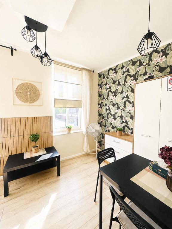 a living room with a table and a chair at Przy Parku Róż II in Chorzów
