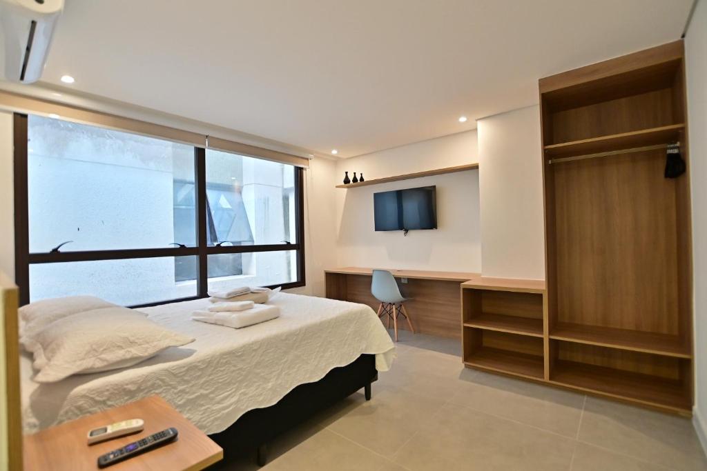 a bedroom with a bed and a window and a desk at Premium Office-My Stay 02 in Brasília