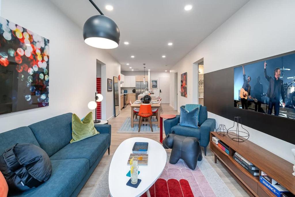 a living room with a blue couch and a table at Hyve-Retro Modern-Full Gym-Walk to Broadway in Nashville
