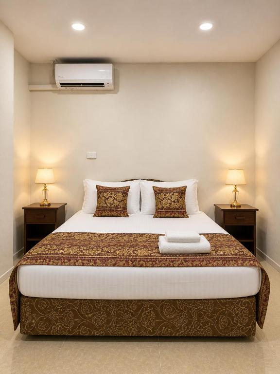 a bedroom with a large bed with two night stands at The Zef Apartment in Nadi