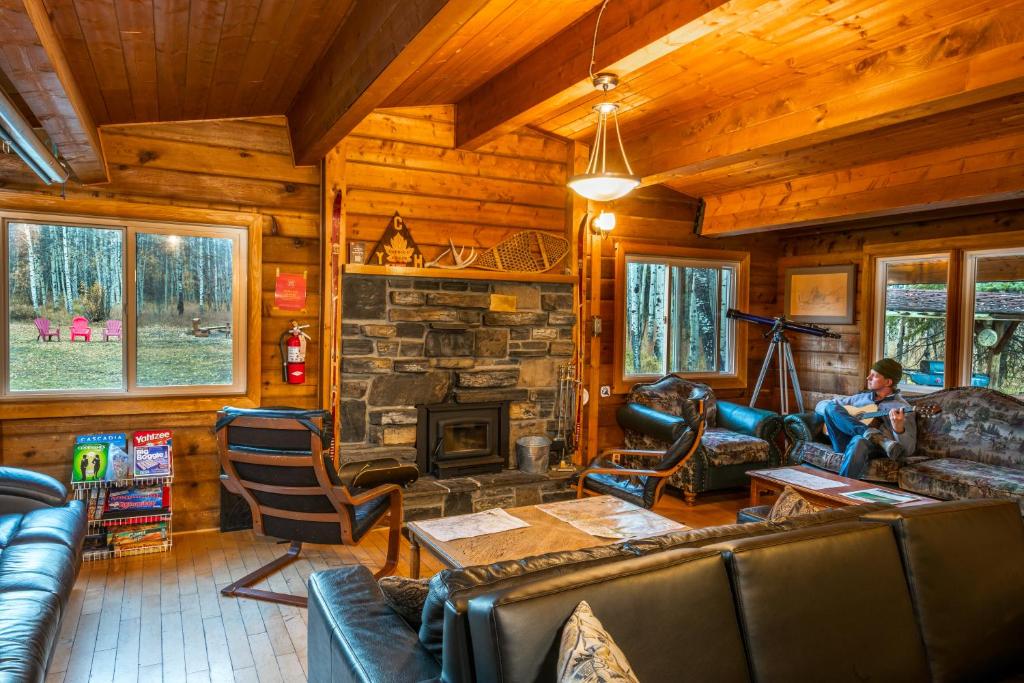 a living room with a fireplace in a log cabin at HI Kananaskis Wilderness - Hostel in Kananaskis Village