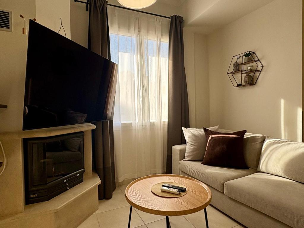 a living room with a couch and a tv at Little Spyrela in Sinarádes