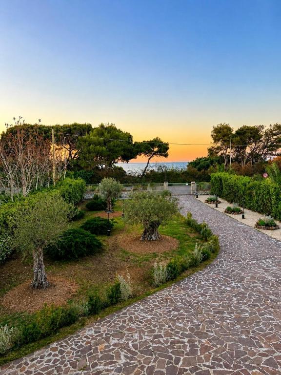 a walkway with trees and bushes in a park at Elba Essence Suites in Portoferraio