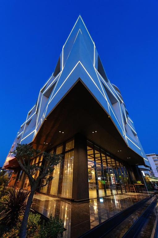 a large building with a geometric facade at night at Chic Boutique Hotel Vlore in Vlorë