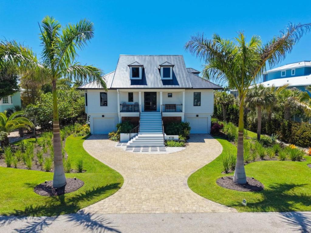 a house with palm trees in front of it at Pelican's Perch in Sanibel