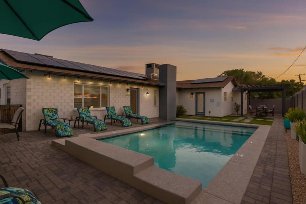 a swimming pool with chairs and a house at Pristine Sunset- In Old Town - Private Pool - BBQ in Scottsdale
