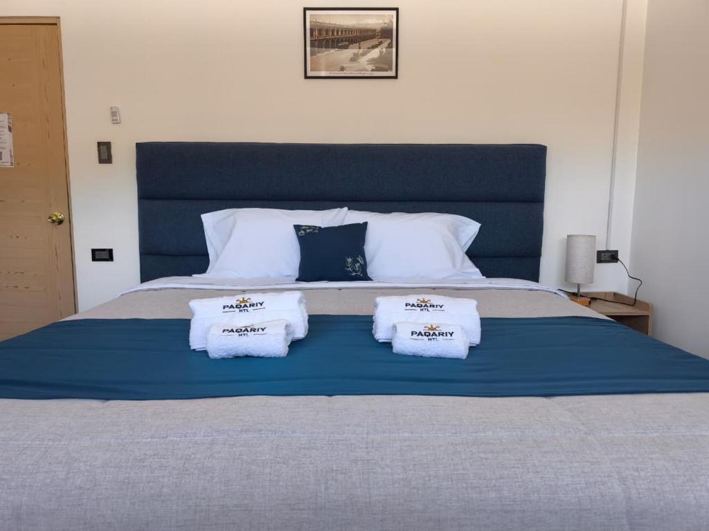 a blue bed with three pillows on top of it at PAQARIY Hs in Arequipa