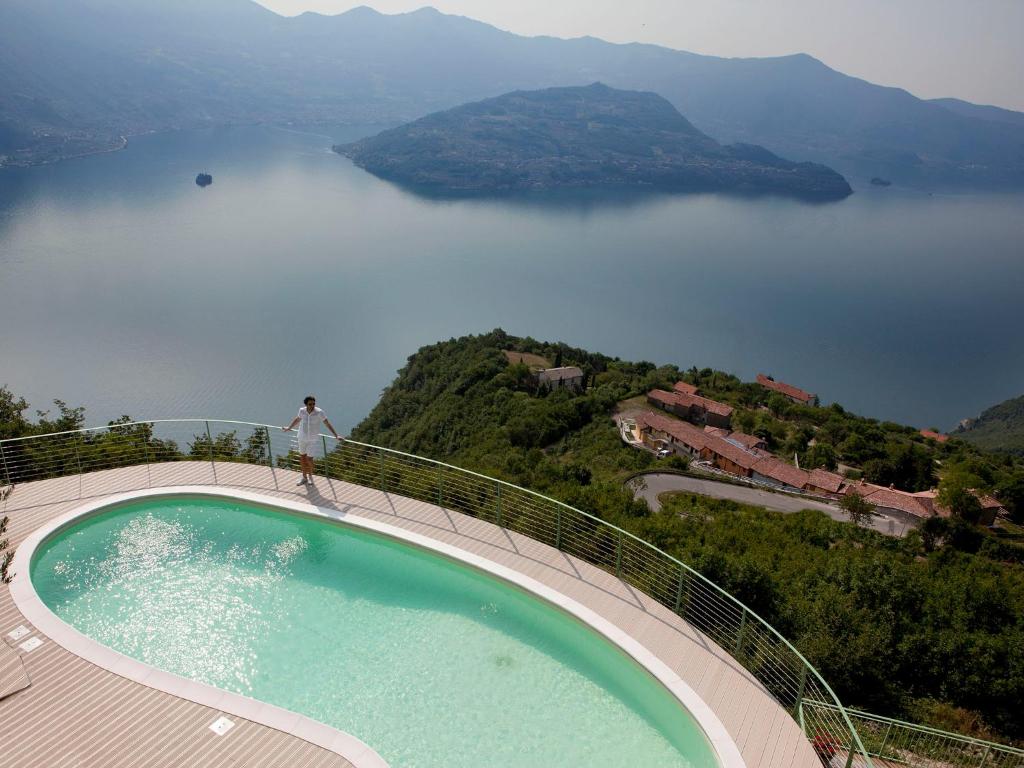 a person standing on the edge of a balcony overlooking a lake at EnjoyIseoLake - Modigliani in Parzanica