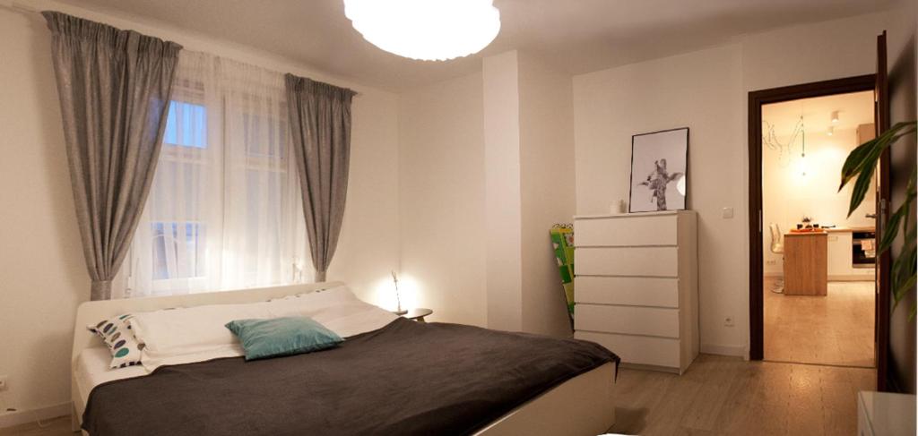 um pequeno quarto com uma cama e uma janela em Kapart Home em Rzeszów