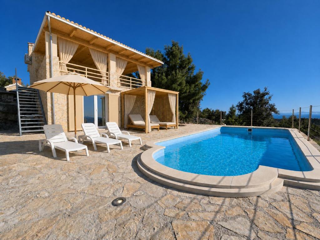 a villa with a swimming pool in front of a house at Villa Aura in Milna