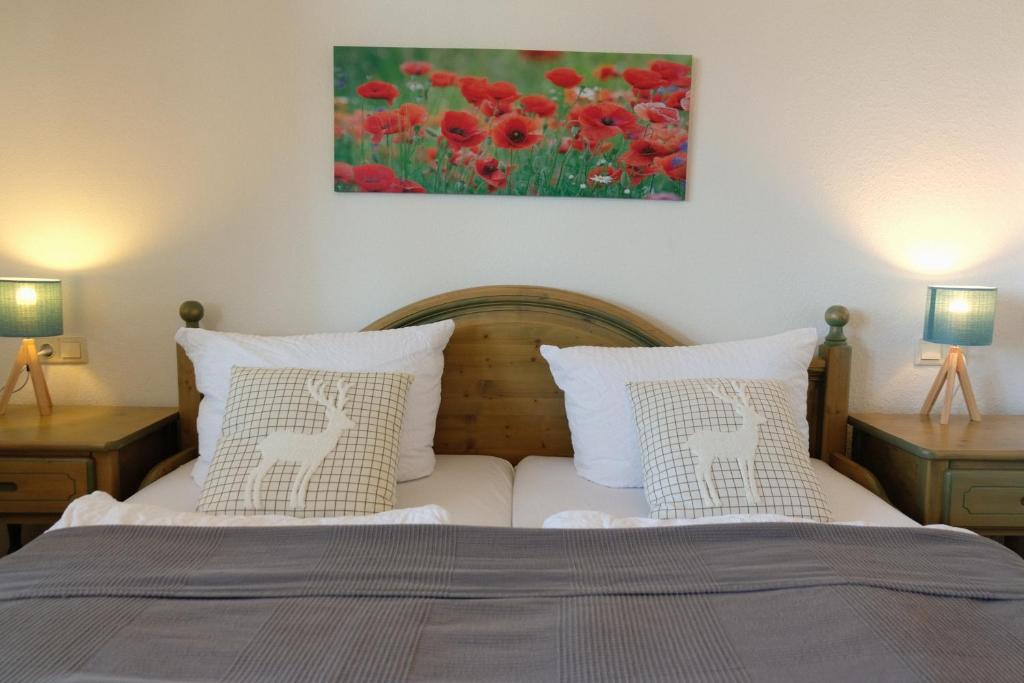 a bedroom with a bed with two lamps and a painting at Villa Lydia in Kurort Altenberg