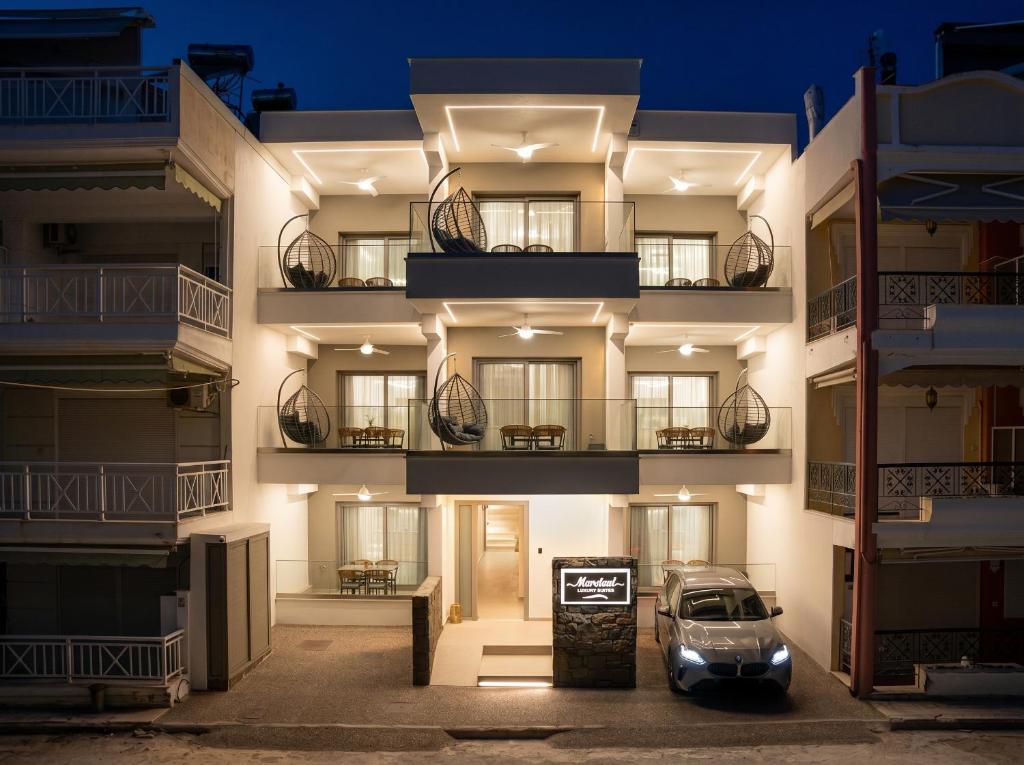 a car parked in front of a building at night at MarAzul Luxury Suites in Flogita