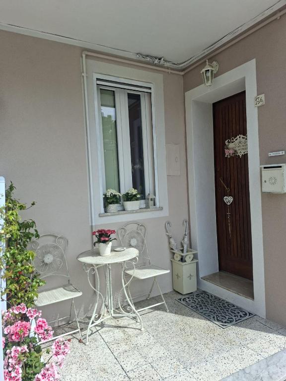 a patio with two chairs and a table and a door at La Petite Maison d'Emilie in Lauria Inferiore