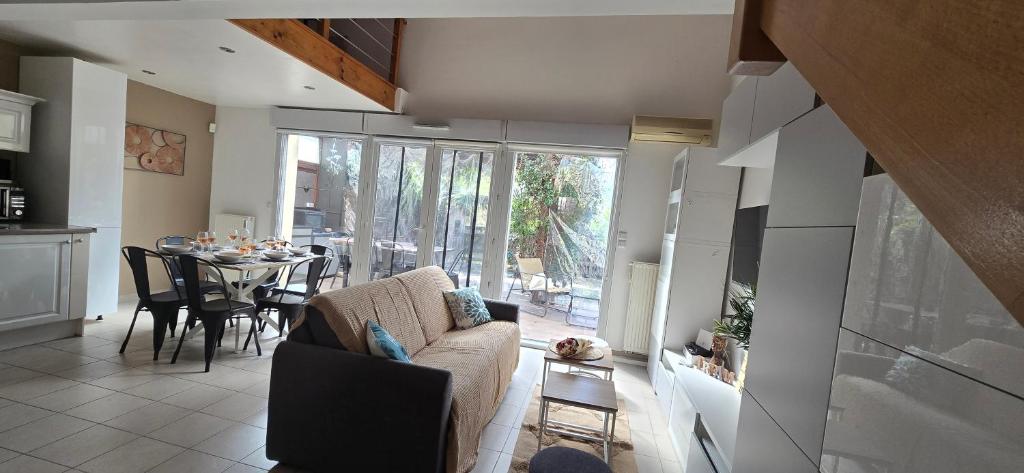 a living room with a couch and a dining table at L eden Maison en Camargue in Salin-de-Giraud