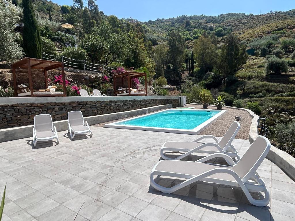a swimming pool with two lounge chairs and a swimming pool at Finca RustiQ in Torrox