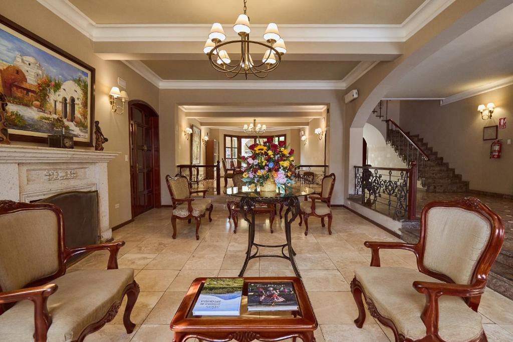 a living room with a table and a fireplace at El Cabildo Hotel in Arequipa