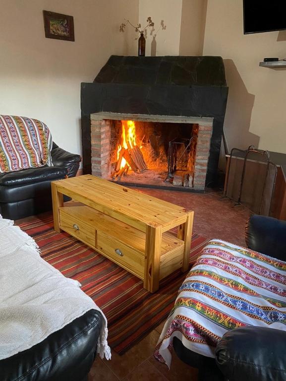 a living room with a fireplace with a wooden coffee table at Departamento Castello in El Bolsón
