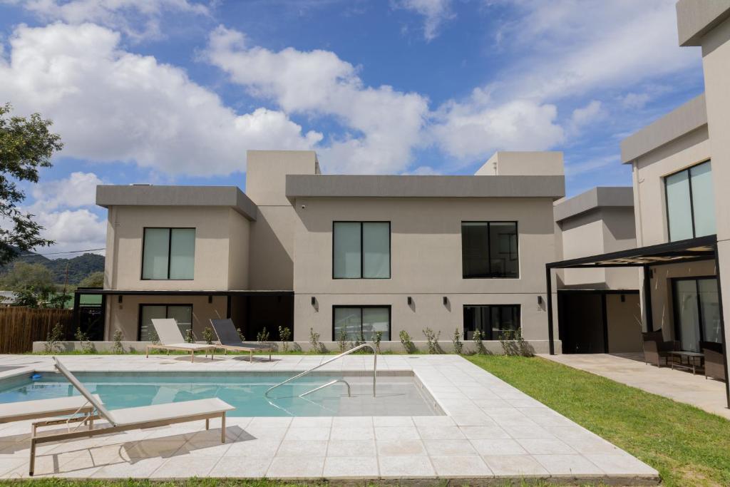 a house with a swimming pool in front of it at Almería Suites in Salta