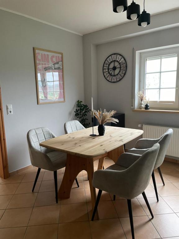 a dining room with a wooden table and chairs at Ferienwohnung Haus Liane in Reil