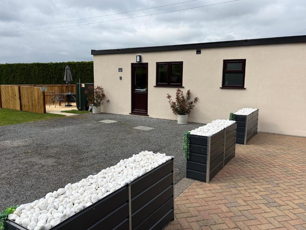 a house with white rocks in front of it at Aloe Lodge in Diss