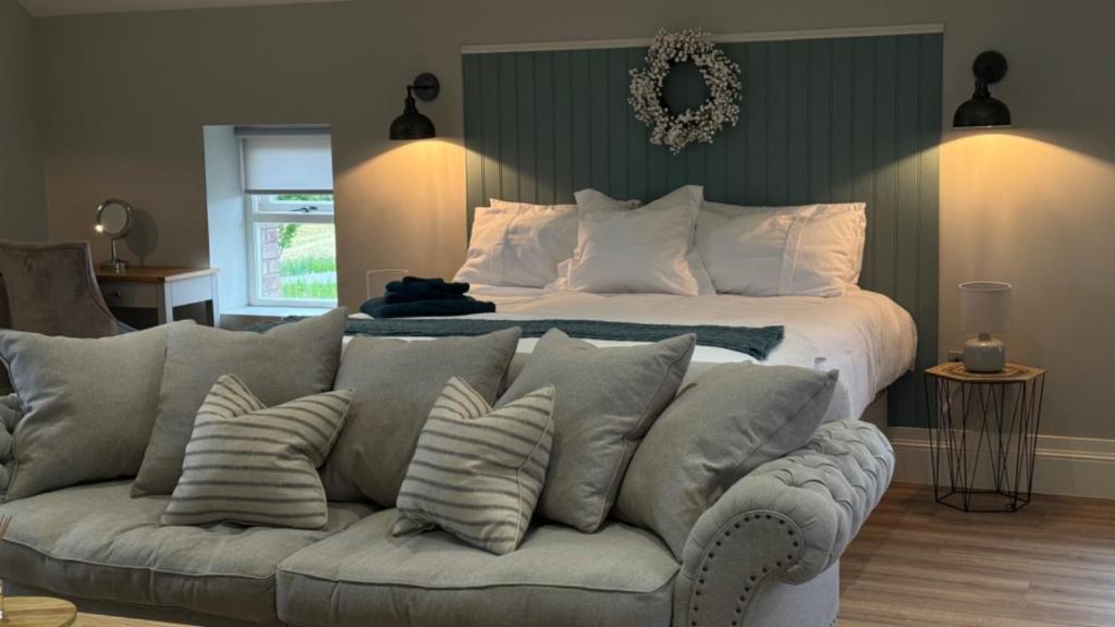 a bedroom with a bed and a couch with pillows at The Loft in Cookstown Junction