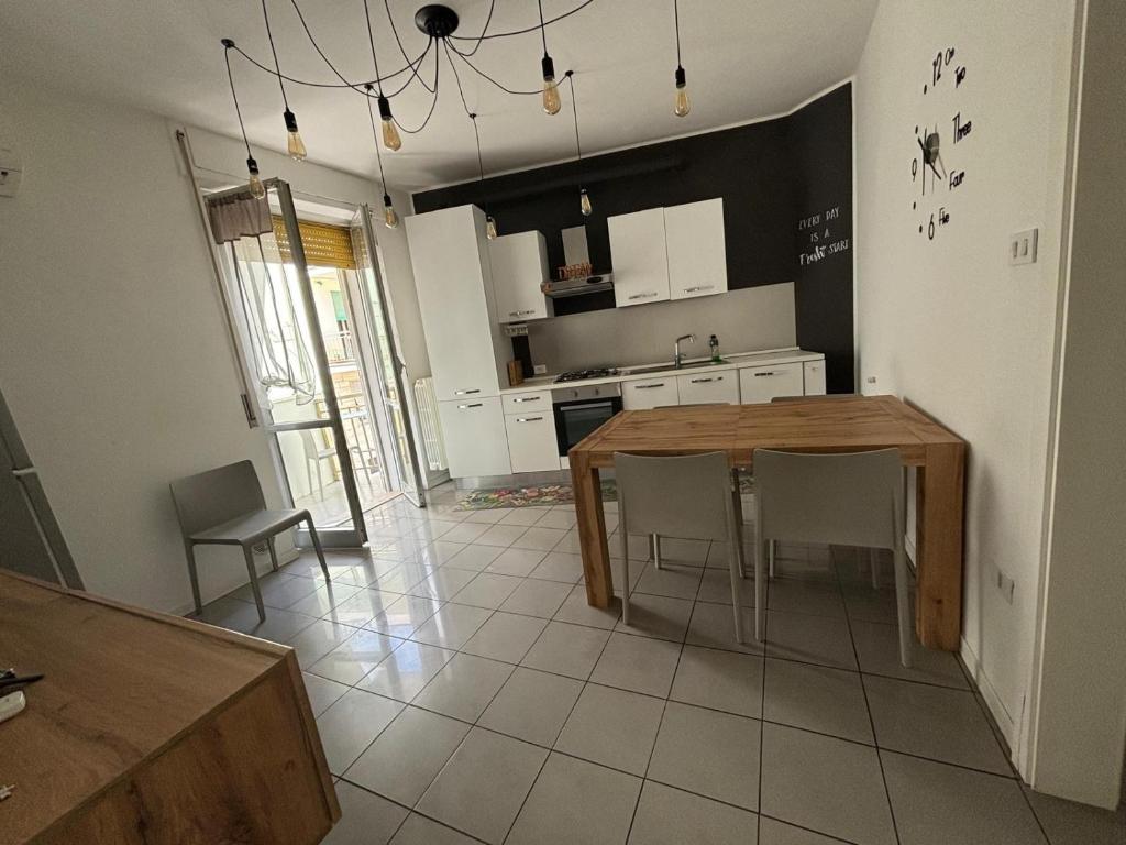 a kitchen with a wooden table and chairs in it at Appartamento Fronte Mare con ombrellone e sedie sdraio incluse nel costo in Pescara