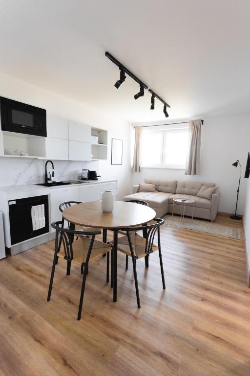 a living room with a table and a kitchen at Malé Lipno 1075 in Černá v Pošumaví