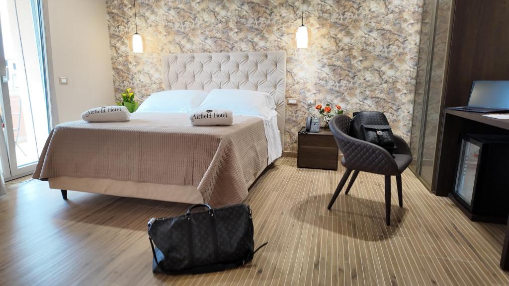 a bedroom with a bed and a black bag at Airfield Hotel & Spa in Vibo Valentia