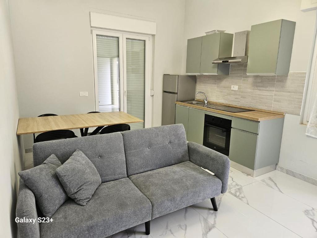 a living room with a couch and a kitchen at Residence Niko 5 Pomezia in Pratica di Mare