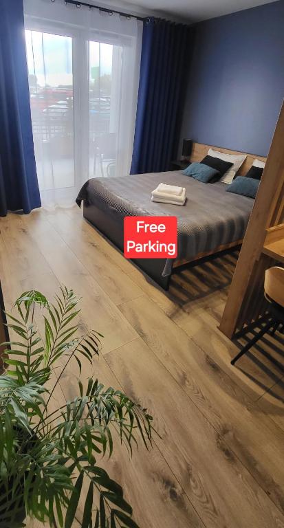 a bedroom with a bed with a free parking sign on it at Apartament - Sienkiewicza 22D in Zamość