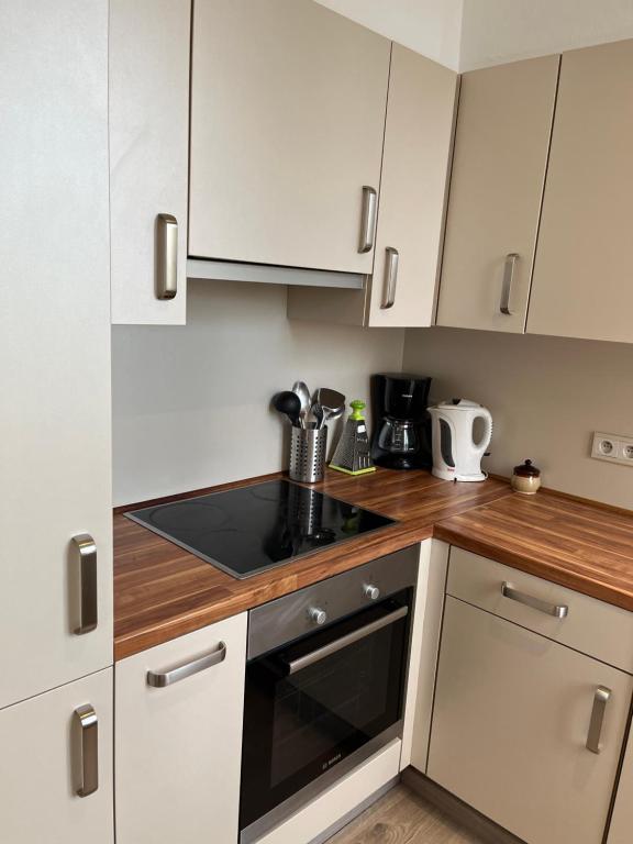 a kitchen with white cabinets and a stove top oven at Cosy uccle chic flat in Brussels