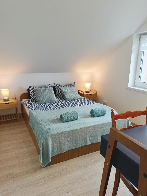 a bedroom with a bed with blue pillows at Pokoje i apartamenty Mak in Łeba