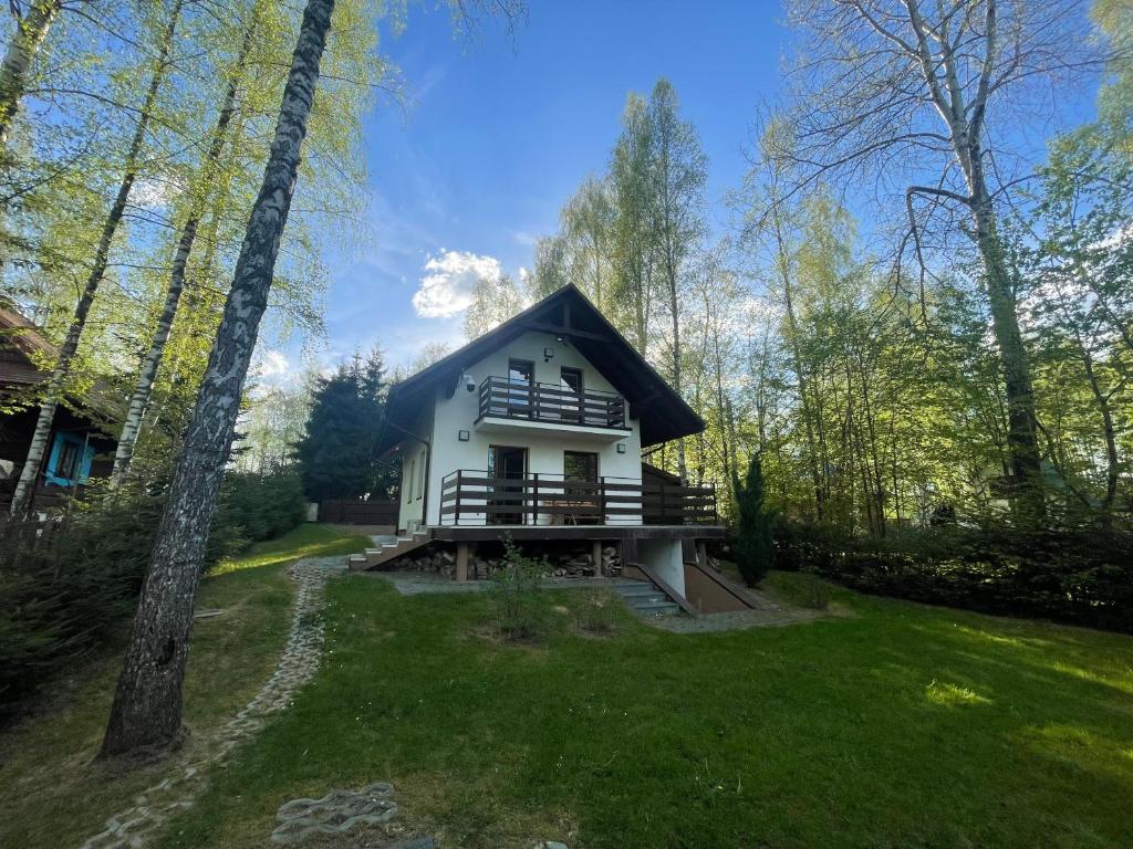 a house with a black roof in the middle of a yard at Przylądek Werlas in Werlas