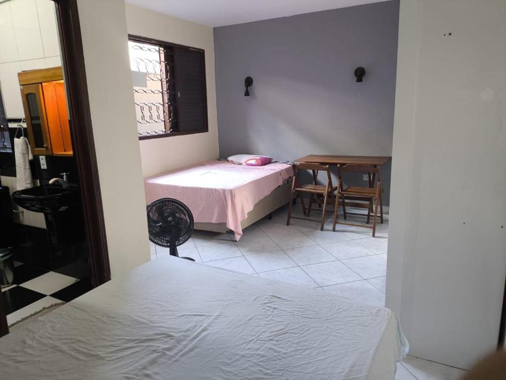a small bedroom with a bed and a table at Quarto Bem Localizado em Lugar Tranquilo in Barueri